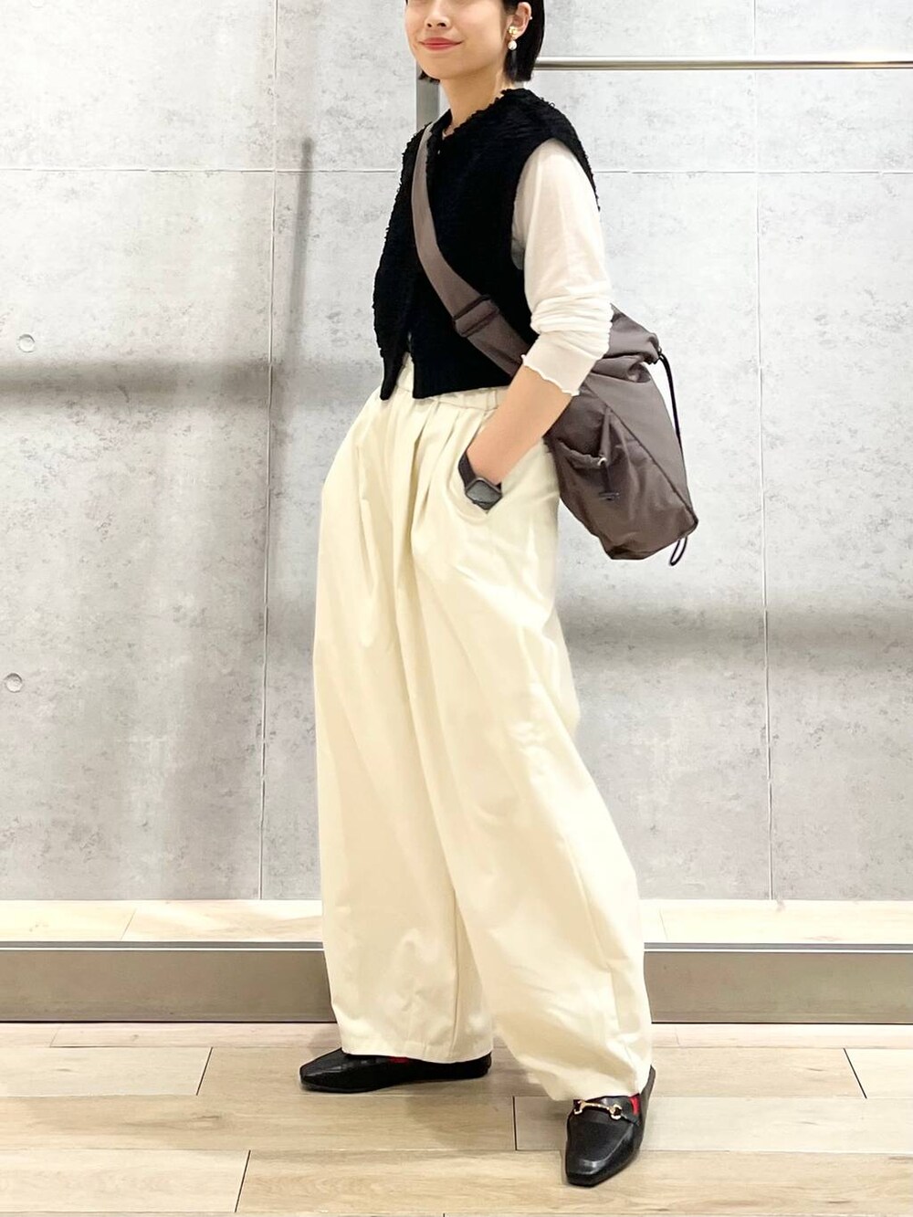 ブラック系のローファー、ホワイト系のTシャツ/カットソー、ブラック系のベストを着用したレディースの秋コーディネートの2枚目の写真