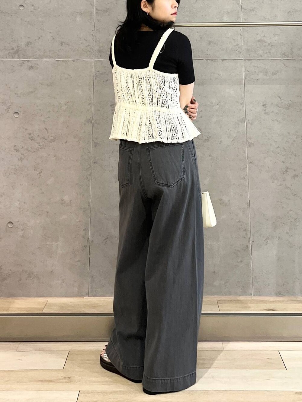 ブラック系のTシャツ/カットソー、シルバー系のサンダル、ブラック系のデニムパンツを着用したレディースの春コーディネートの2枚目の写真
