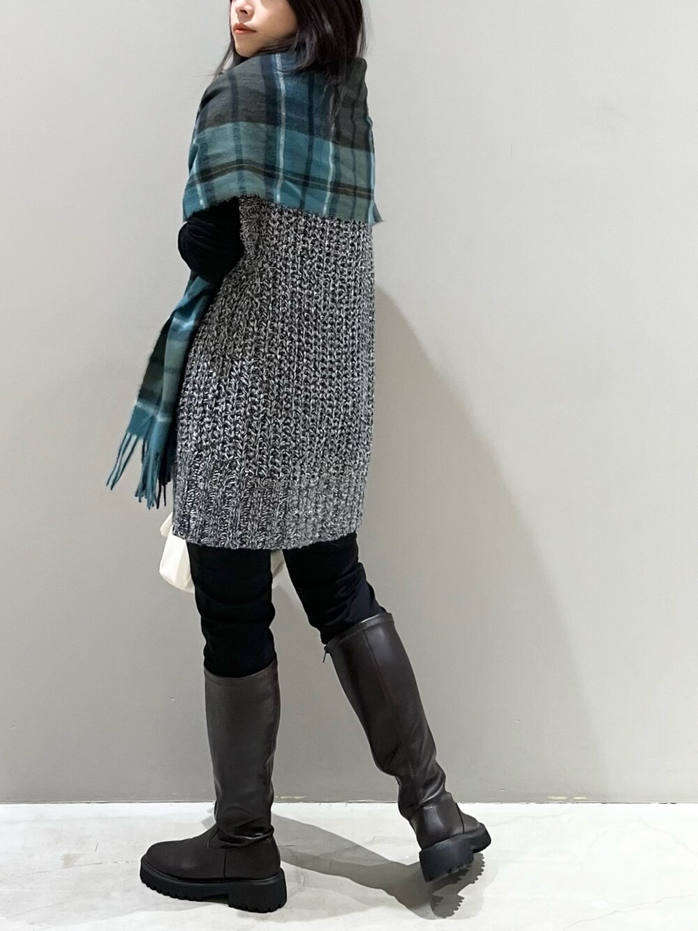 ブラウン系のブーツ、ブラック系のバッグ、ブラック系のその他パンツを着用したレディースの秋コーディネートの4枚目の写真