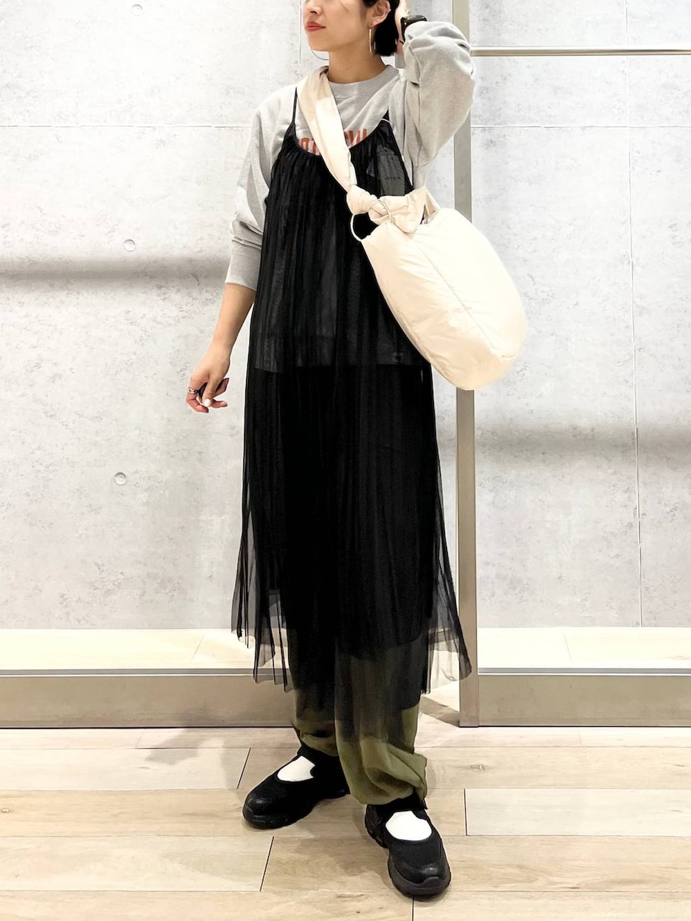 グレー系のスウェット、ブラック系のスニーカー、グリーン系のカーゴパンツを着用したレディースの秋コーディネートの6枚目の写真