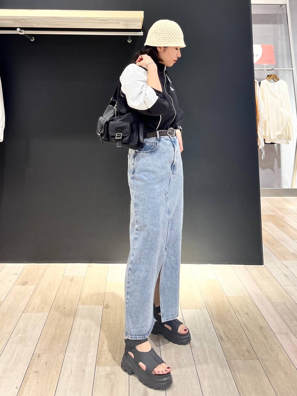 ブルー系のデニムスカート、ブラック系のショルダーバッグ、ブラック系のサンダルを着用したレディースの春コーディネートの6枚目の写真