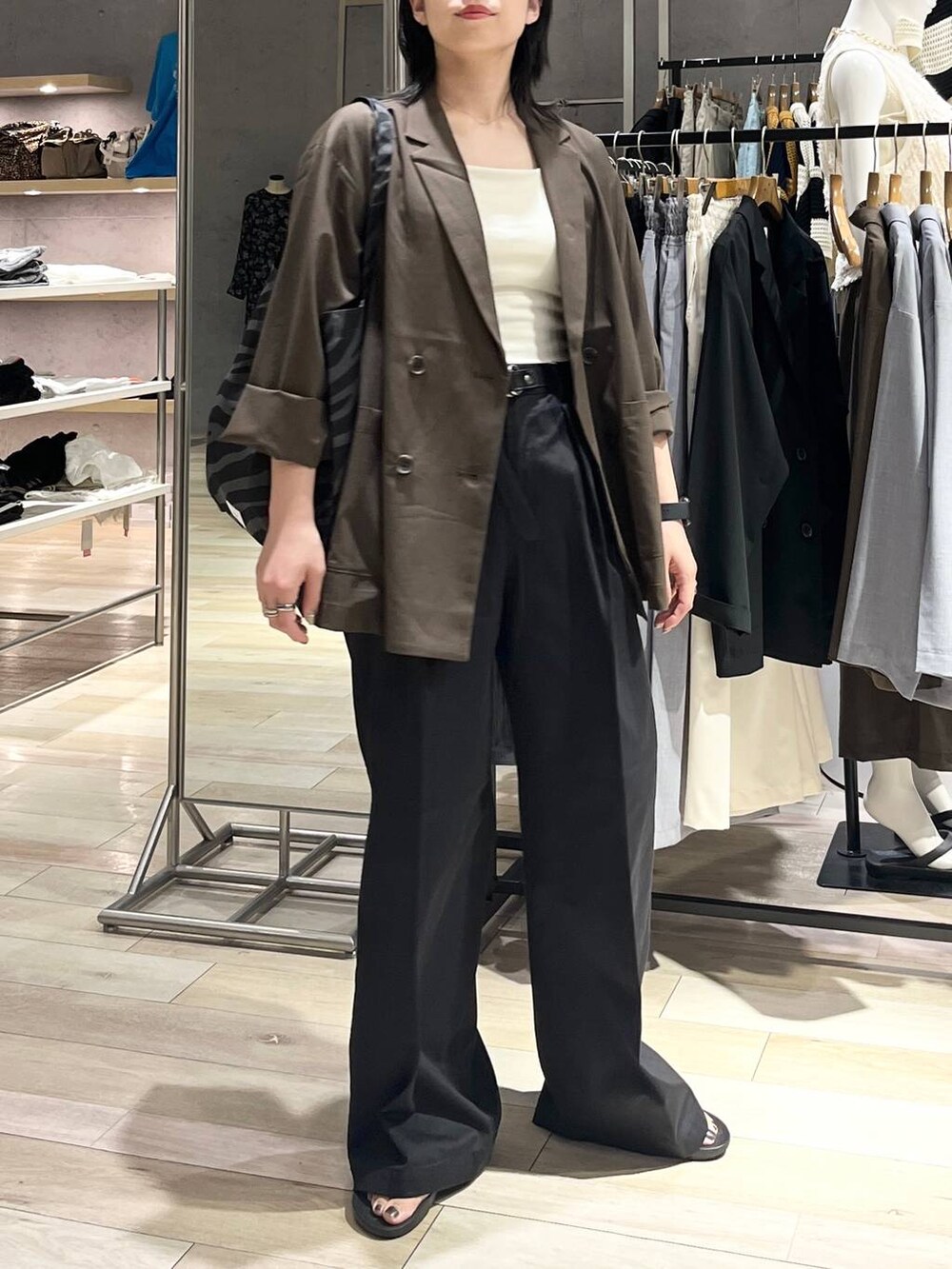 ブラック系のサンダル、グレー系のトートバッグ、ホワイト系のキャミソールを着用したレディースの夏コーディネートの9枚目の写真