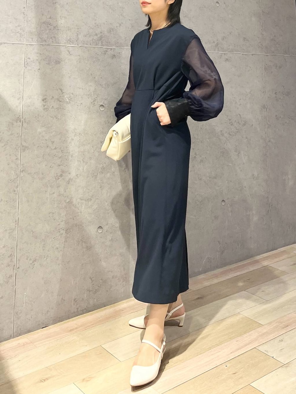 ホワイト系のショルダーバッグ、ホワイト系のパンプス、ブルー系のドレスを着用したレディースの夏コーディネートの5枚目の写真