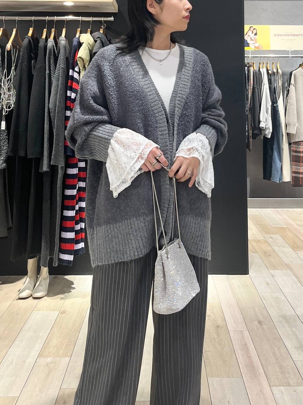 シルバー系のショルダーバッグ、ブラック系のブーツ、ホワイト系のTシャツ/カットソーを着用したレディースの秋コーディネートの5枚目の写真