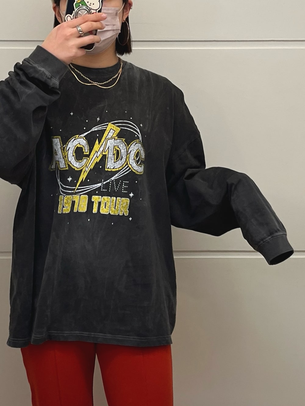 オレンジ系のその他パンツ、グレー系のTシャツ/カットソー、ゴールド系のネックレスを着用したレディースの冬コーディネートの2枚目の写真