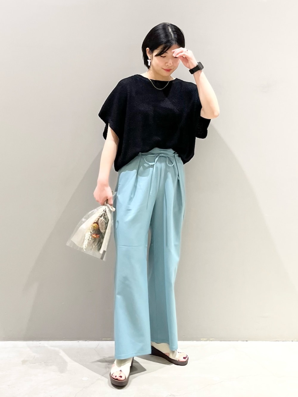 ブラック系のその他トップス、グリーン系のスラックス、ホワイト系のサンダルを着用したレディースの春コーディネートの3枚目の写真