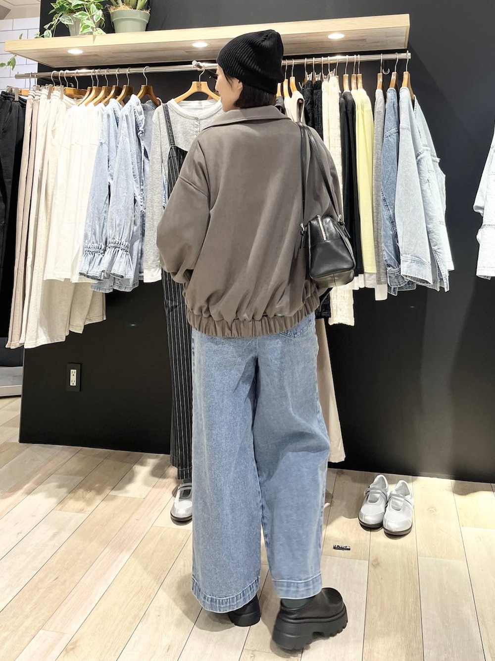 ブラック系のボストンバッグ、ブラック系のブーツ、ブルー系のサロペット/オーバーオールを着用したレディースの冬コーディネートの4枚目の写真