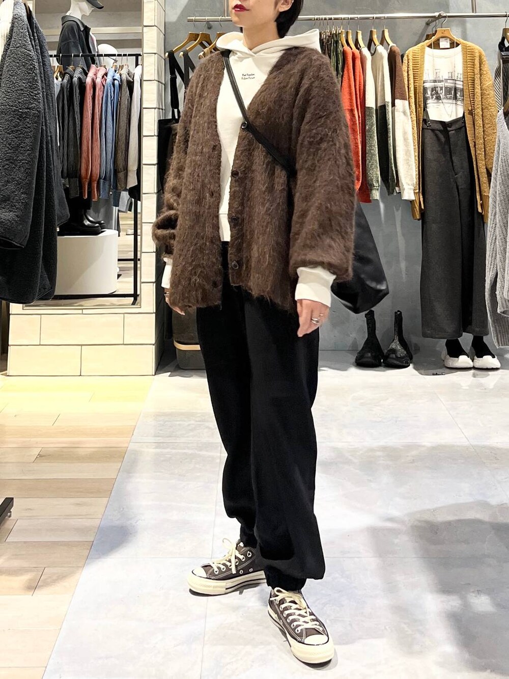 ブラウン系のスニーカー、ブラック系のその他パンツ、ブラウン系のカーディガン/ボレロを着用したレディースの秋コーディネートの2枚目の写真