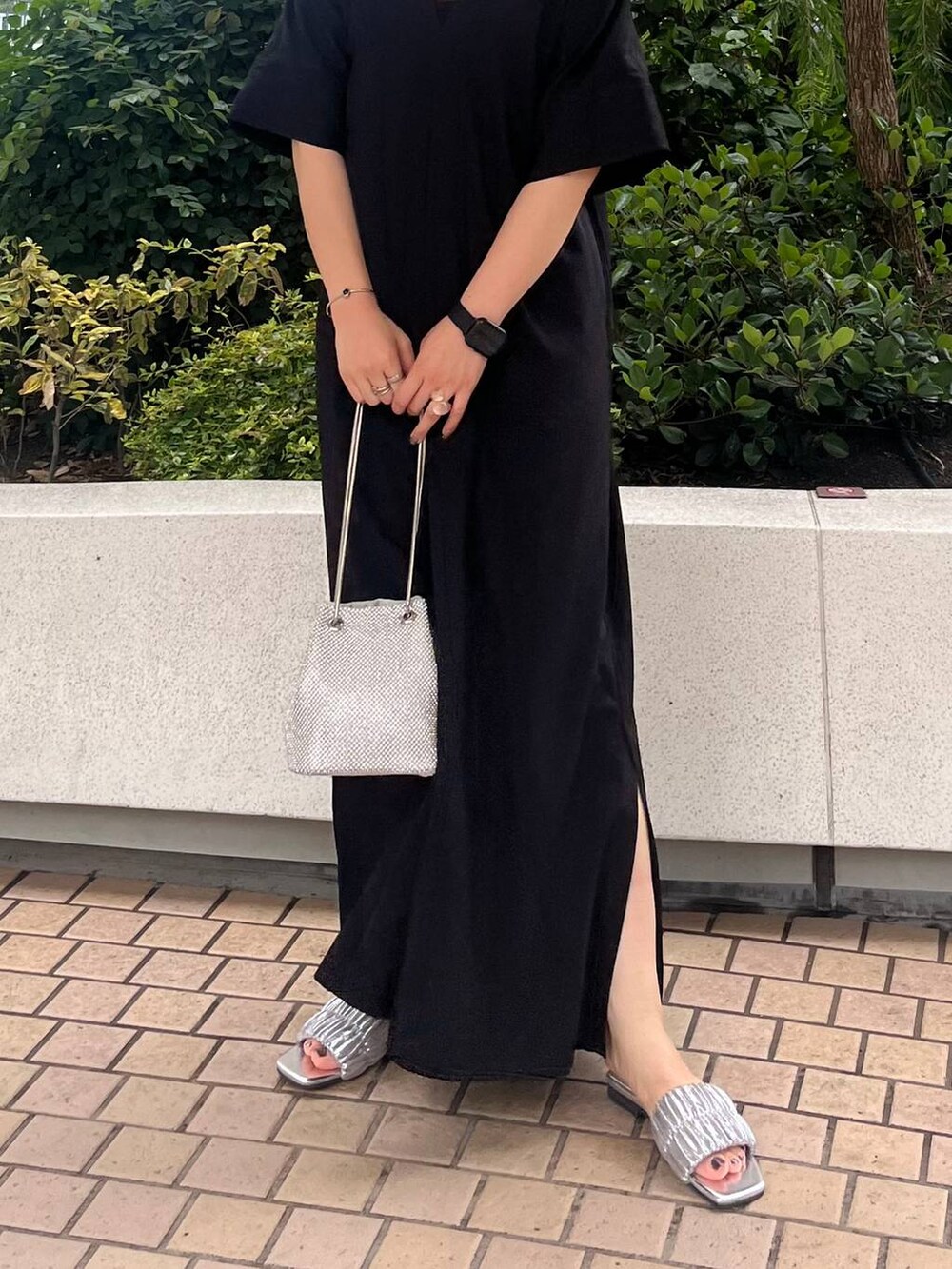 シルバー系のショルダーバッグ、ブラック系のワンピース、シルバー系のネックレスを着用したレディースの夏コーディネートの4枚目の写真