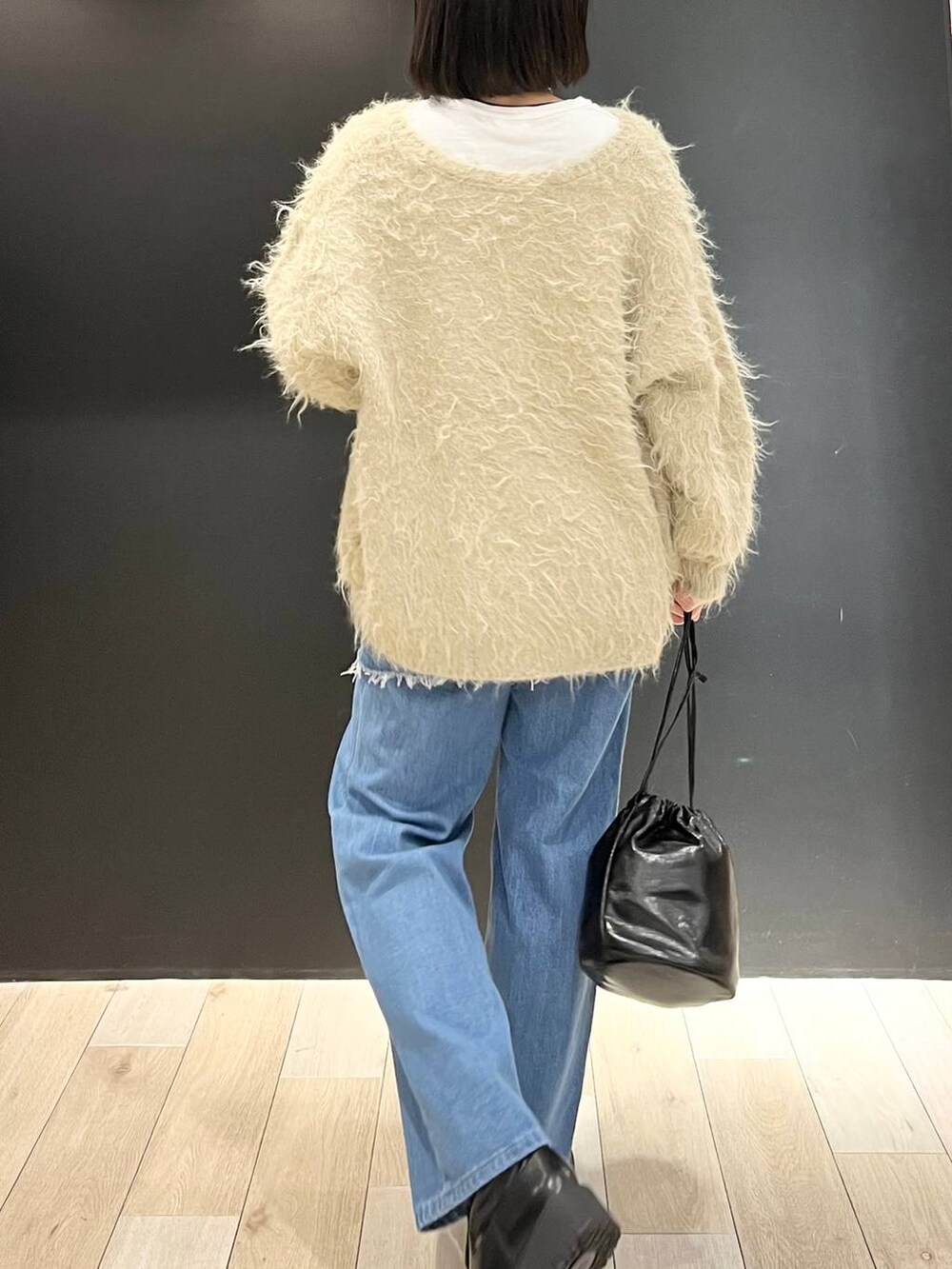 ホワイト系のTシャツ/カットソー、ブラック系のブーツ、ベージュ系のカーディガン/ボレロを着用したレディースの冬コーディネートの6枚目の写真