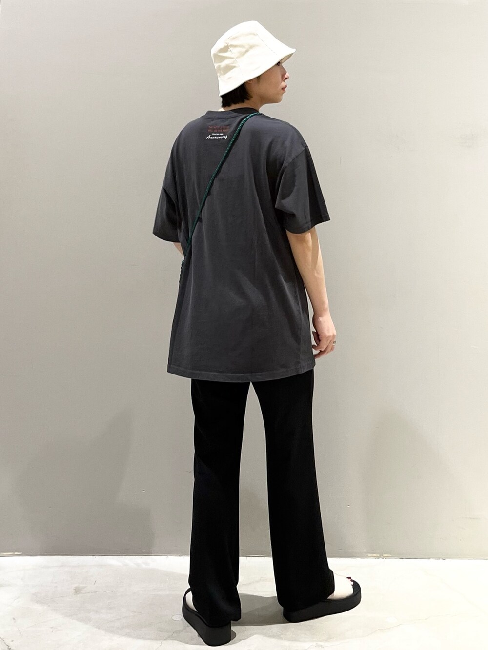 ブラック系のパンツ、ホワイト系のサンダル、グリーン系のショルダーバッグを着用したレディースの秋コーディネートの6枚目の写真