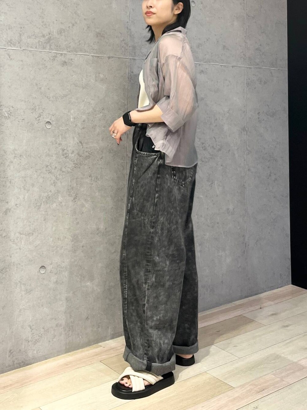 シルバー系のショルダーバッグ、ホワイト系のサンダル、グレー系のデニムパンツを着用したレディースの夏コーディネートの6枚目の写真