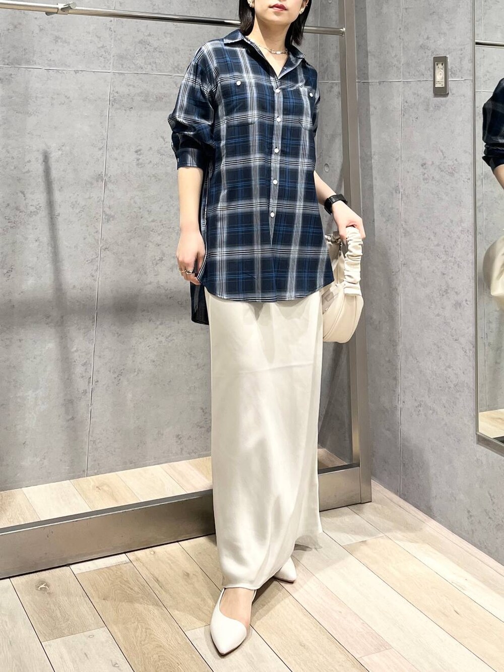 ホワイト系のショルダーバッグ、ホワイト系のスカート、ブルー系のシャツ/ブラウスを着用したレディースの冬コーディネートの2枚目の写真