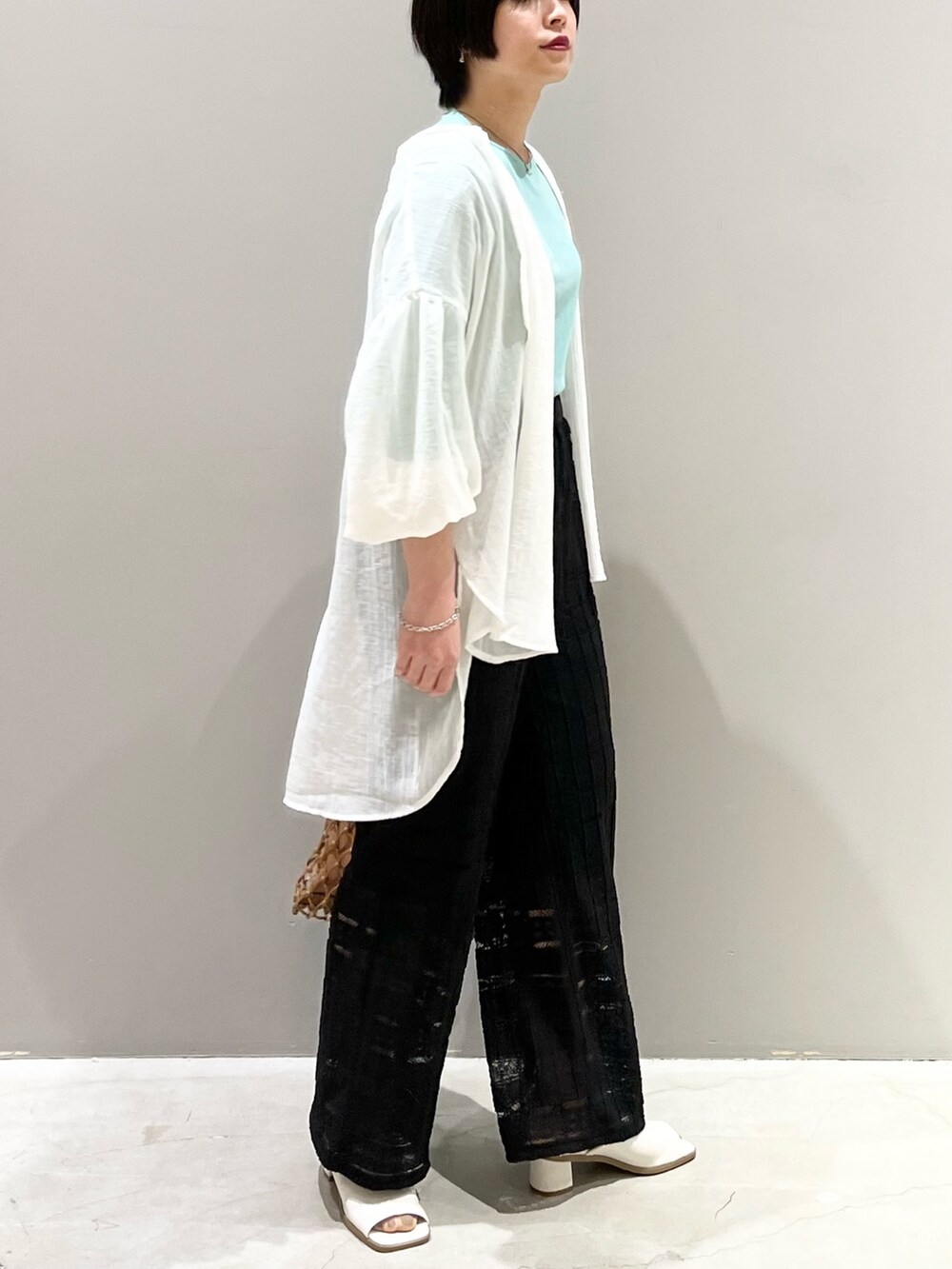 ブラック系のその他パンツ、ホワイト系のサンダル、ベージュ系のバッグを着用したレディースの春コーディネートの6枚目の写真