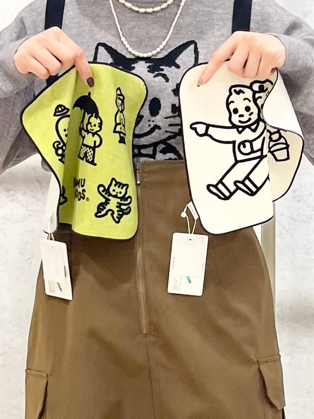 ブラック系のモカシン/デッキシューズ、ブラウン系のスカート、グレー系のニット/セーターを着用したレディースの冬コーディネートの2枚目の写真