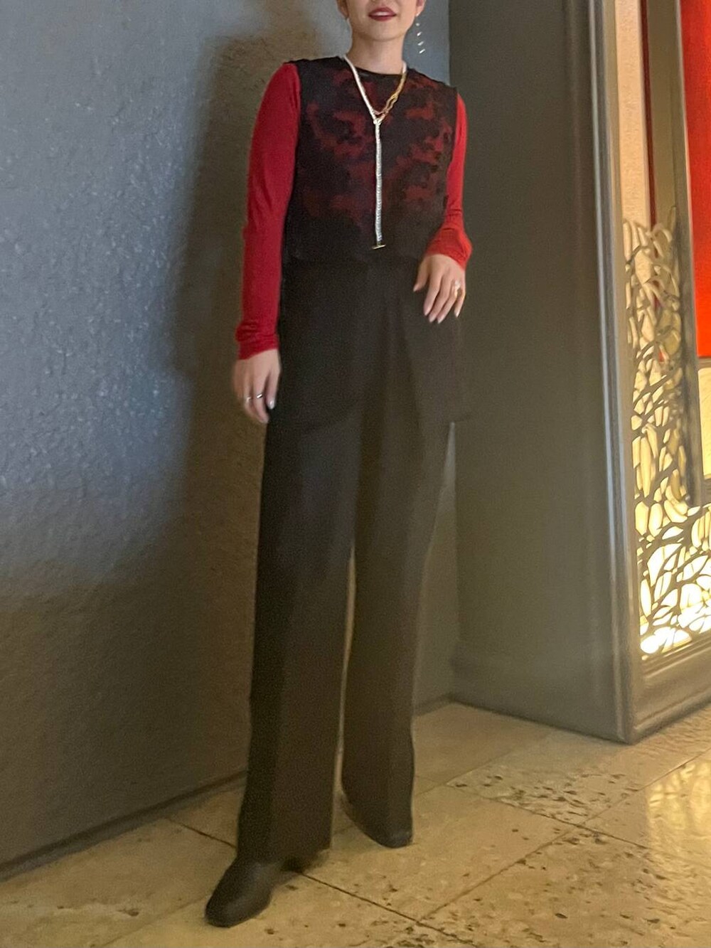 レッド系のTシャツ/カットソー、ブラック系のショルダーバッグ、ブラック系のその他パンツを着用したレディースの冬コーディネートの9枚目の写真