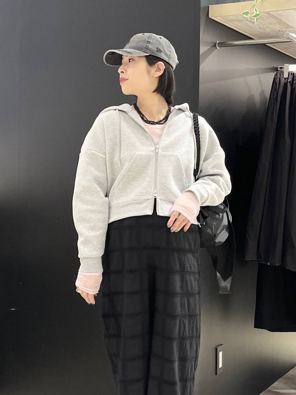 ピンク系のTシャツ/カットソー、ブラック系のショルダーバッグ、ブラック系のスニーカーを着用したレディースの春コーディネートの2枚目の写真