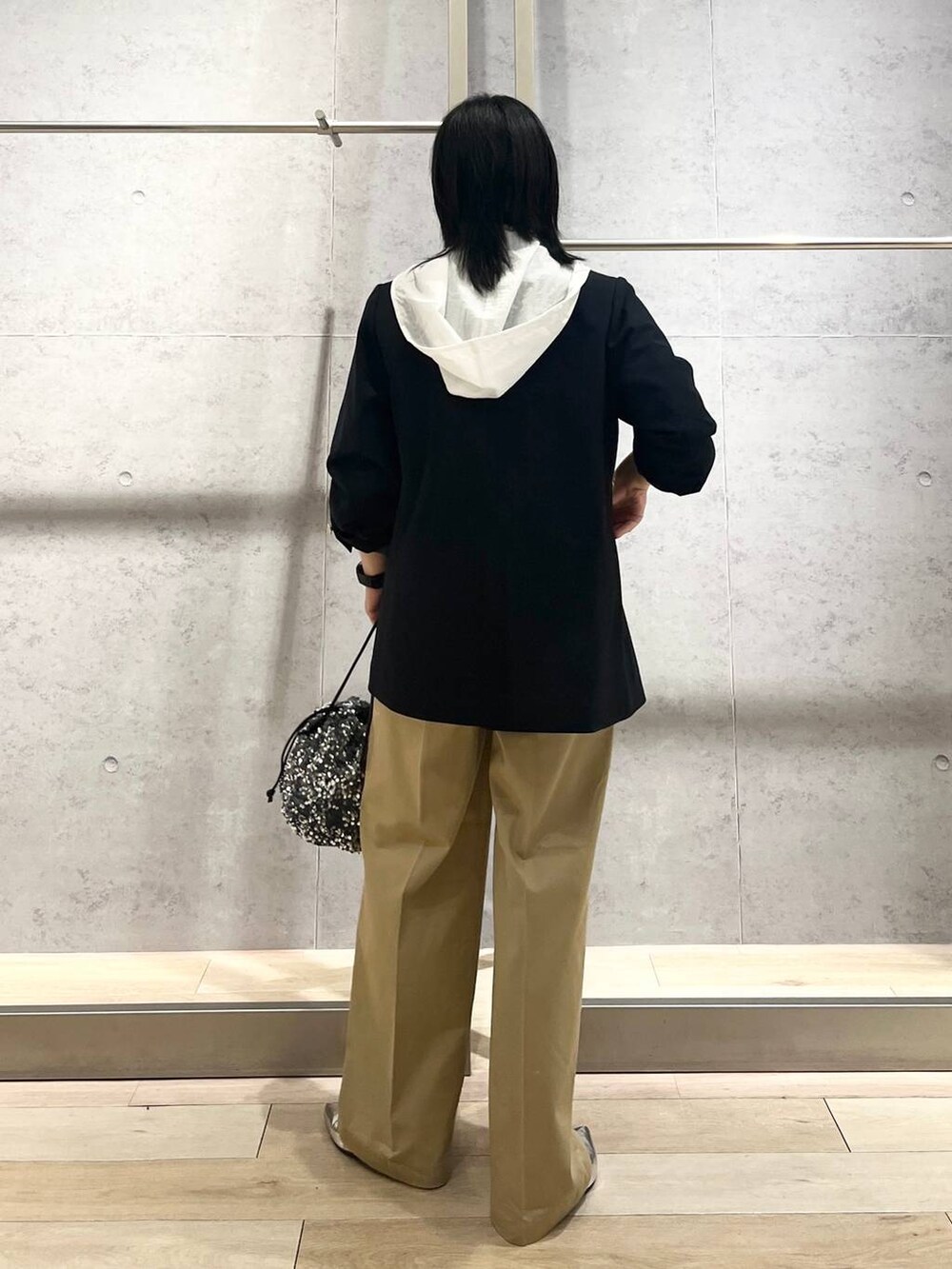 ブルー系のテーラードジャケット、ベージュ系のチノパンツ、ホワイト系のタンクトップを着用したレディースの夏コーディネートの5枚目の写真