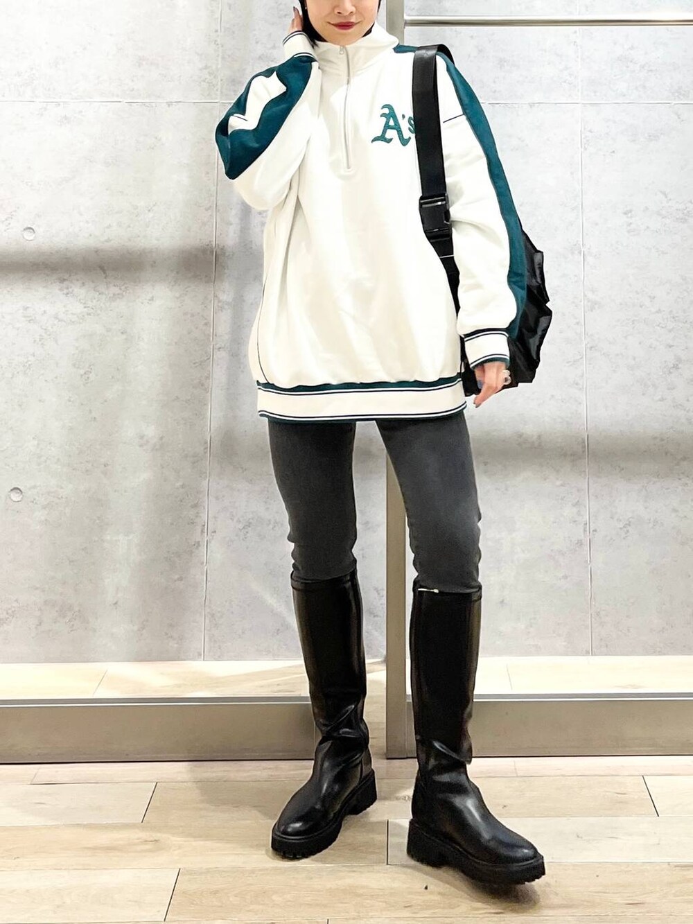 ホワイト系のTシャツ/カットソー、ブラック系のブーツ、グレー系のデニムパンツを着用したレディースの冬コーディネートの8枚目の写真