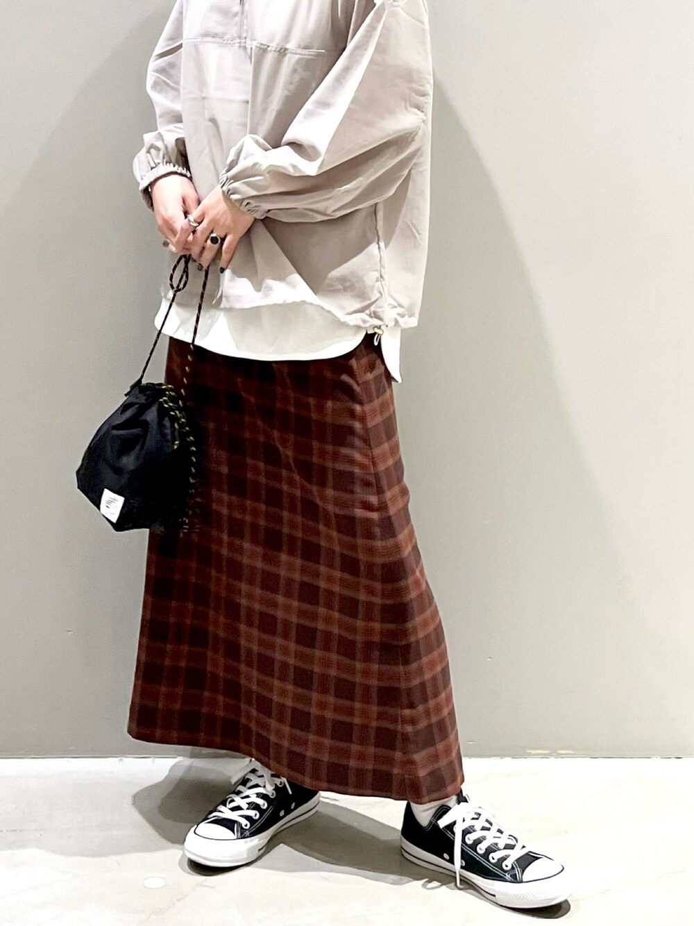 ブラック系のショルダーバッグ、ブラック系のスニーカー、グレー系のトップスを着用したレディースの冬コーディネートの2枚目の写真