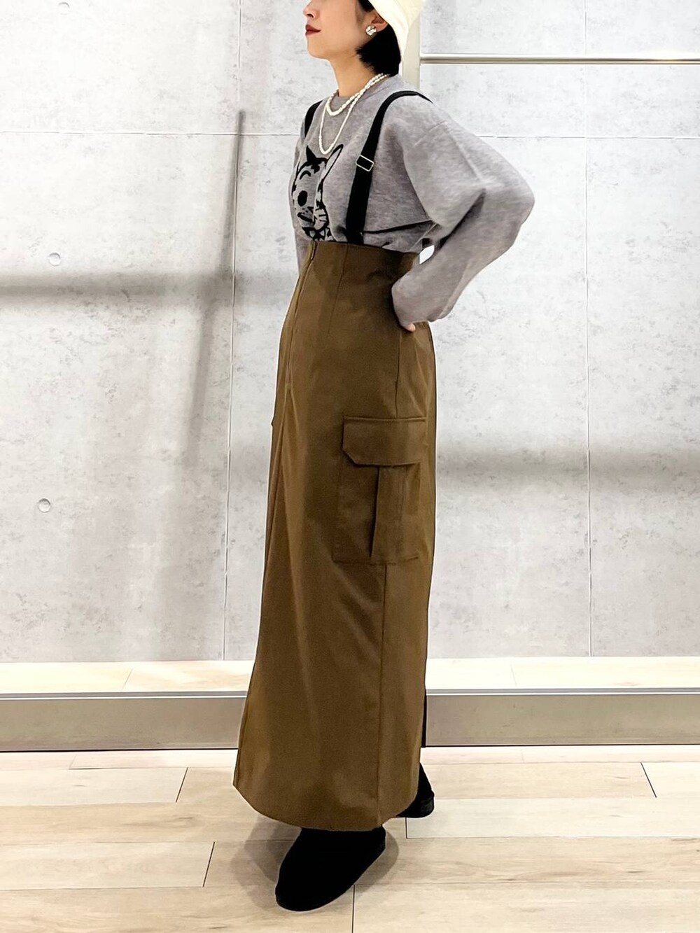 ブラック系のモカシン/デッキシューズ、ブラウン系のスカート、グレー系のニット/セーターを着用したレディースの冬コーディネートの9枚目の写真