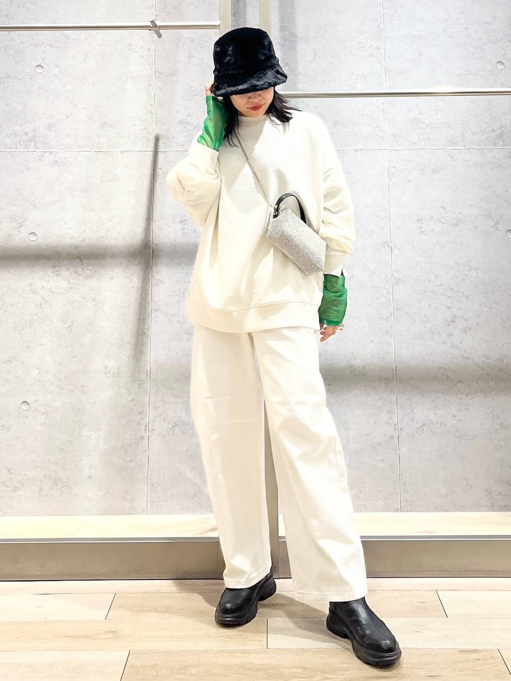 ブラック系のTシャツ/カットソー、ホワイト系のスウェット、ブラック系のブーツを着用したレディースの冬コーディネートの2枚目の写真