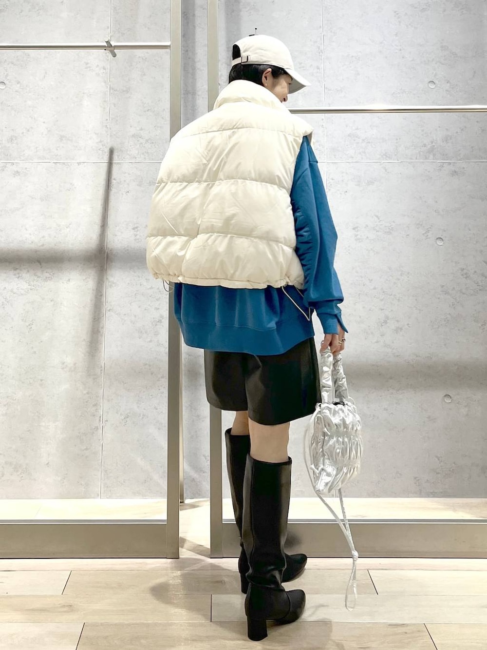 ホワイト系のダウンベスト、シルバー系のショルダーバッグ、ブラック系のその他パンツを着用したレディースの冬コーディネートの5枚目の写真