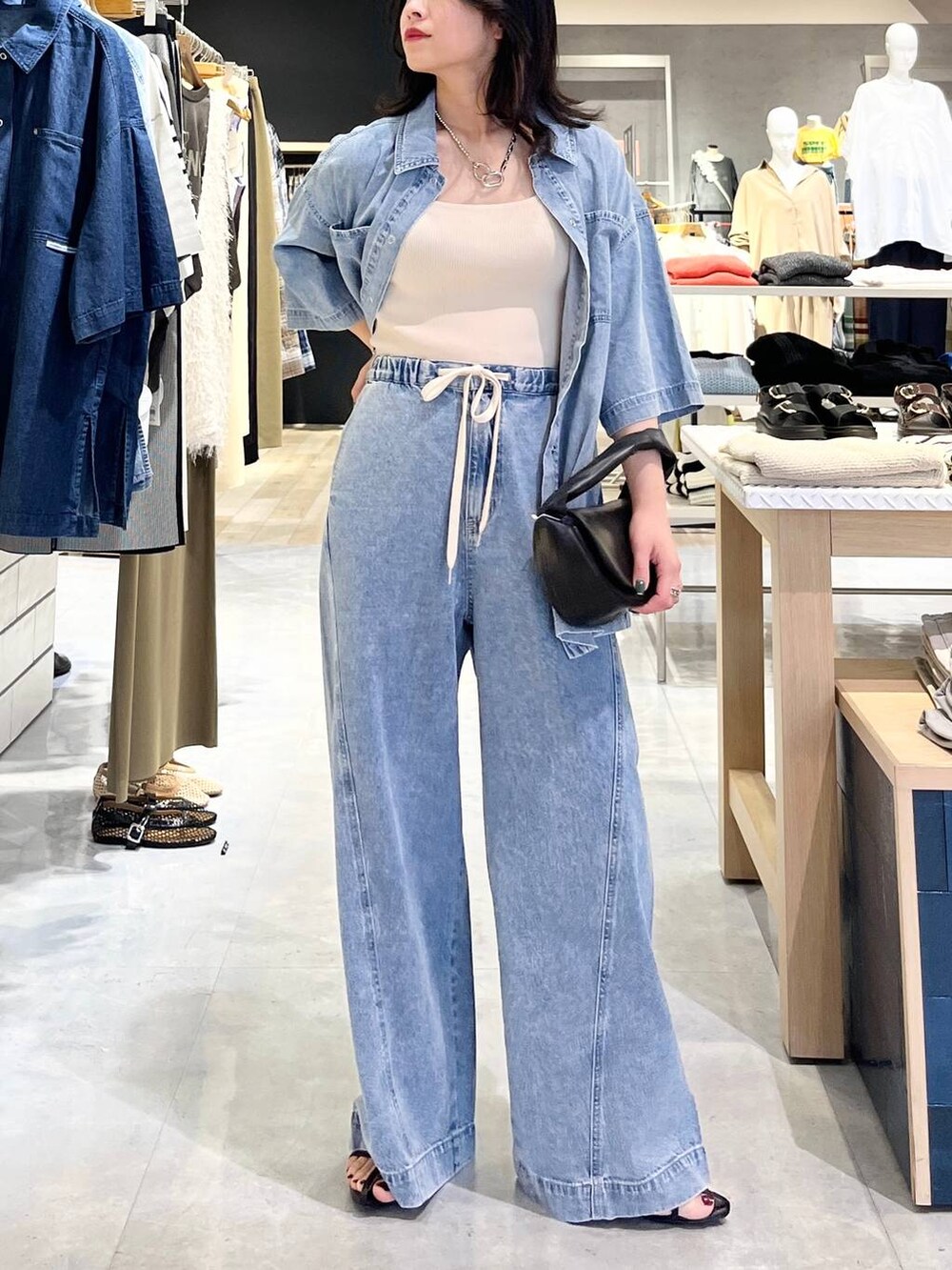 ブルー系のシャツ/ブラウス、ホワイト系のタンクトップ、ブルー系のデニムパンツを着用したレディースの春コーディネートの5枚目の写真