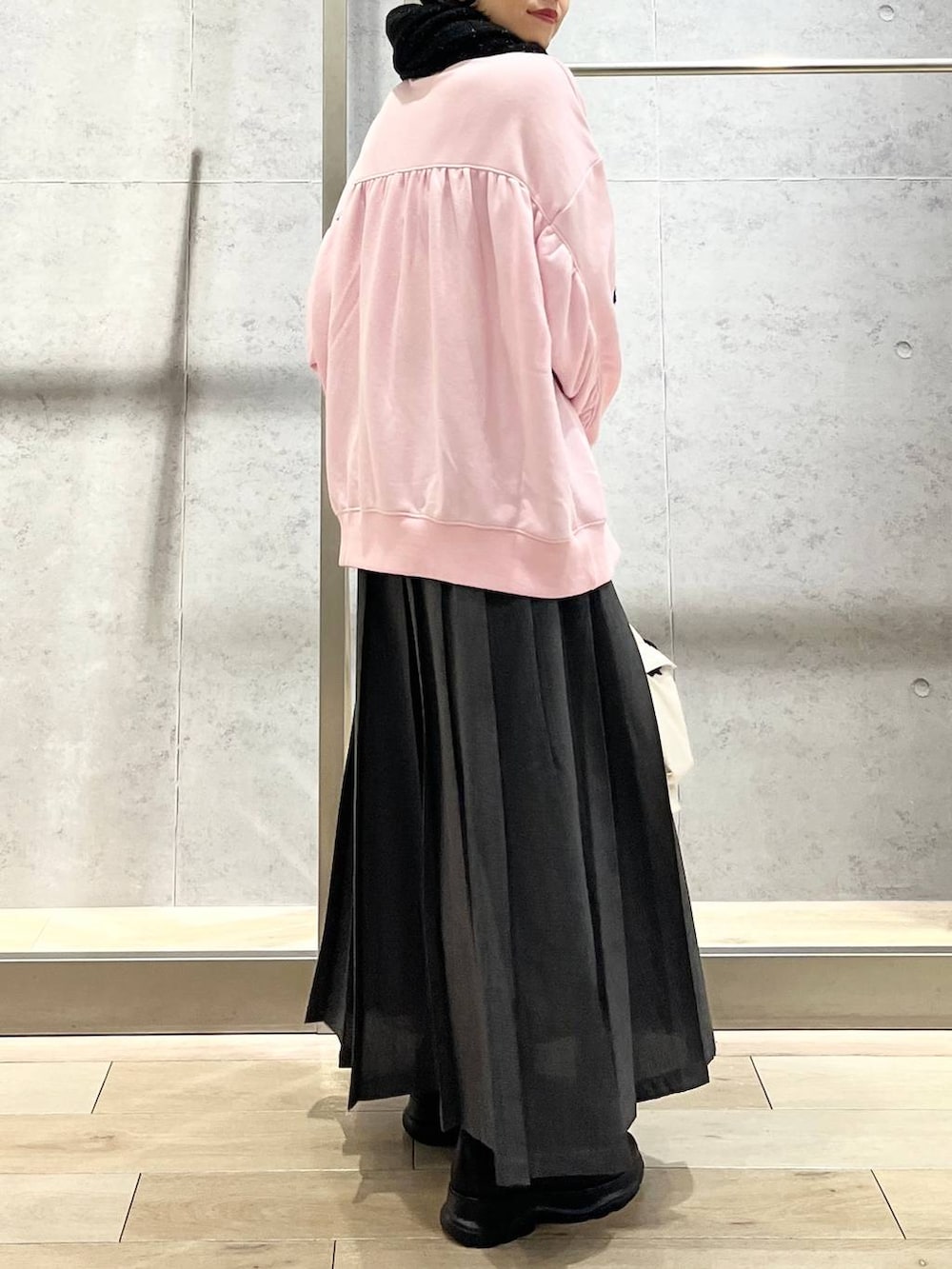 ホワイト系のショルダーバッグ、ピンク系のスウェット、ブラック系のブーツを着用したレディースの秋コーディネートの3枚目の写真