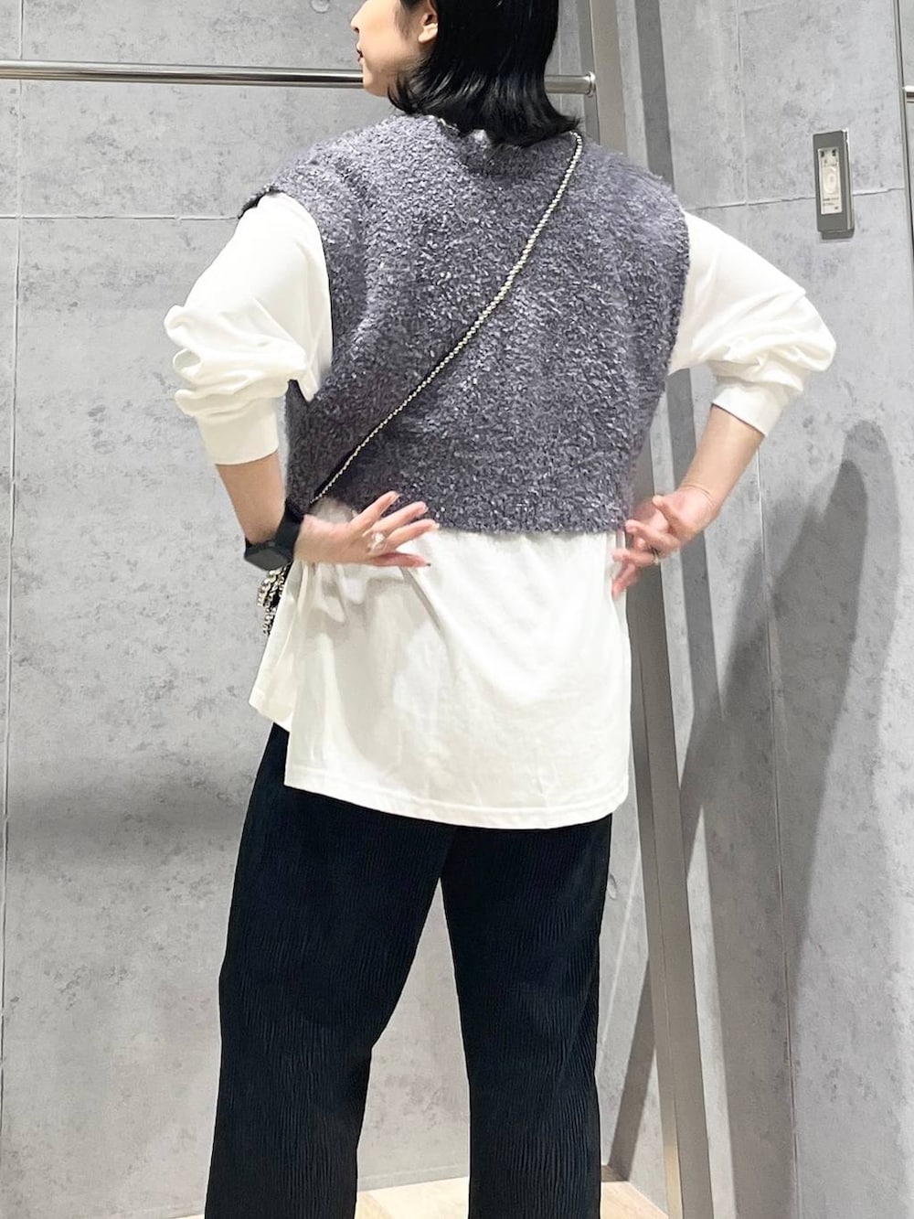 シルバー系のショルダーバッグ、ブラック系のワンピース、シルバー系のパンプスを着用したレディースの秋コーディネートの6枚目の写真