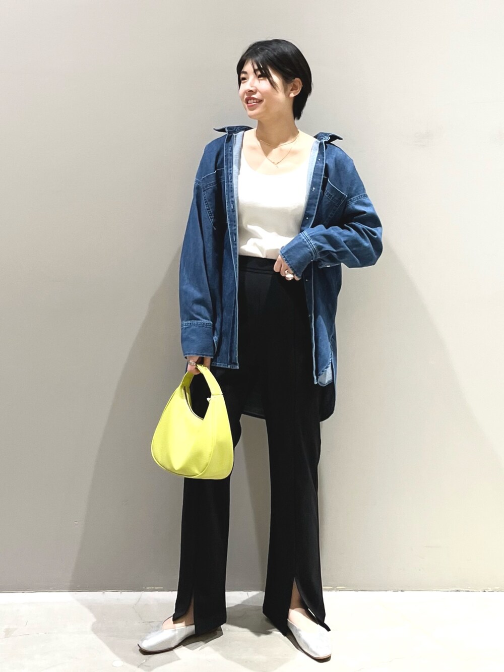 イエロー系のショルダーバッグ、ブラック系のその他パンツ、グレー系のパンプスを着用したレディースの春コーディネートの4枚目の写真