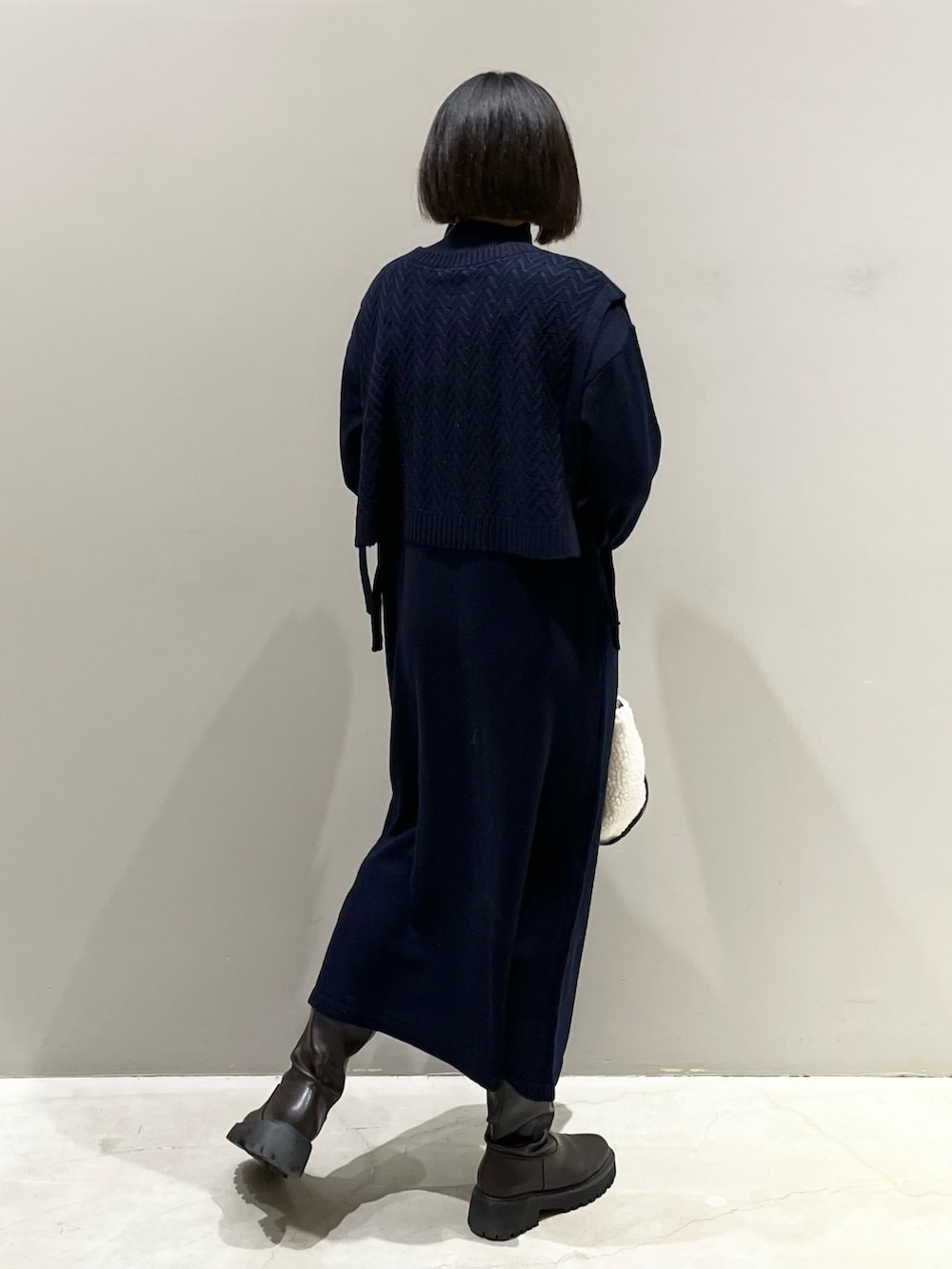 ホワイト系のバッグ、ブラウン系のブーツ、ブルー系のマタニティウェア/グッズを着用したレディースの冬コーディネートの3枚目の写真