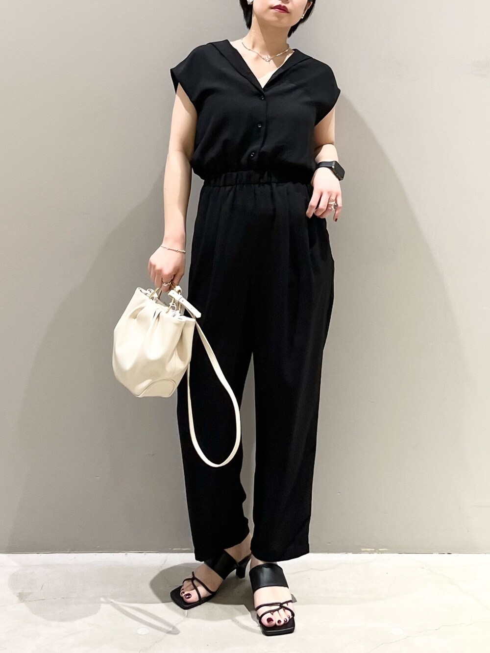 ブラック系のつなぎ/オールインワン、ホワイト系のバッグ、ブラック系のサンダルを着用したレディースの春コーディネートの2枚目の写真