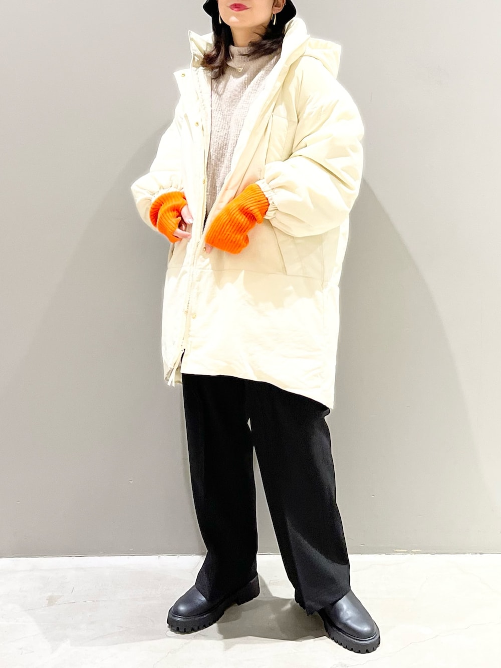 ブラウン系のニット/セーター、ホワイト系のジャケット/アウター、ブラック系のパンツを着用したレディースの冬コーディネートの3枚目の写真