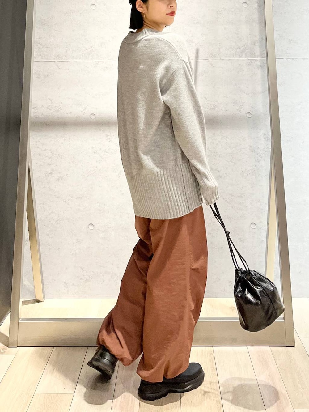 グレー系のその他パンツ、ブラック系のブーツ、グレー系のニット/セーターを着用したレディースの秋コーディネートの5枚目の写真