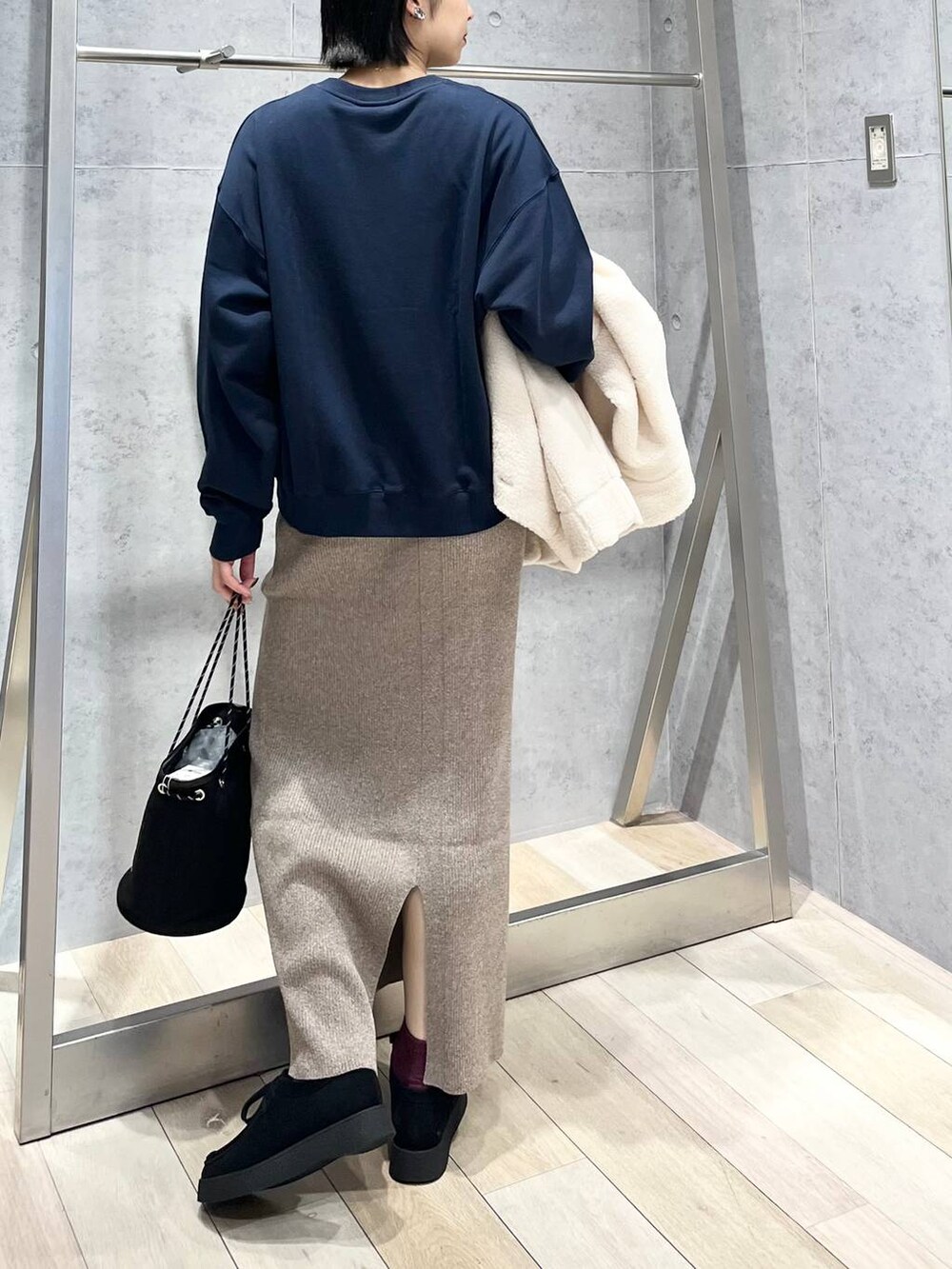 ブルー系のTシャツ/カットソー、ホワイト系のブルゾン、ブラック系のモカシン/デッキシューズを着用したレディースの秋コーディネートの6枚目の写真