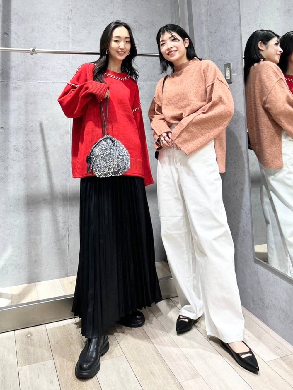 シルバー系のショルダーバッグ、ブラック系のブーツ、ホワイト系のデニムパンツを着用したレディースの冬コーディネートの2枚目の写真