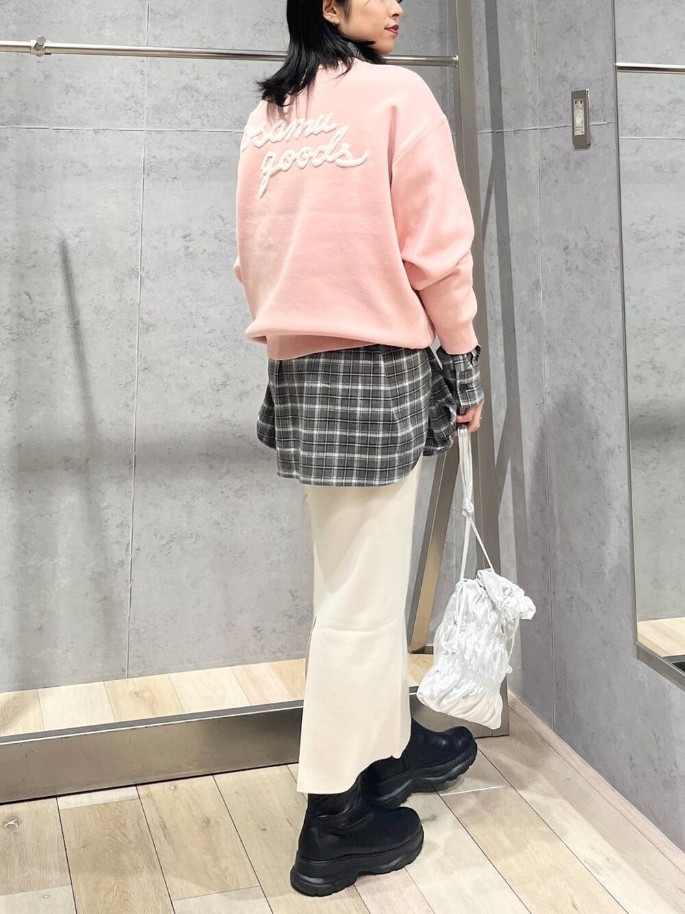 シルバー系のショルダーバッグ、ホワイト系のスカート、ブラック系のブーツを着用したレディースの冬コーディネートの3枚目の写真