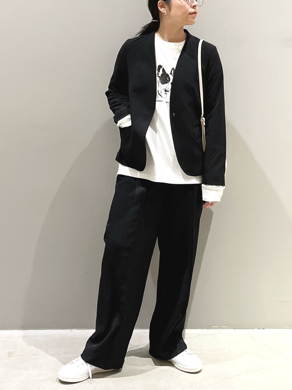 ブラック系のパンツ、ホワイト系のスニーカー、ホワイト系のショルダーバッグを着用したレディースの秋コーディネートの5枚目の写真