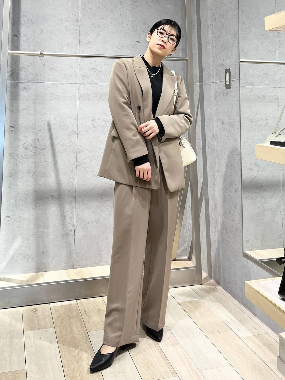 ブラック系のニット/セーター、ブラウン系のスーツパンツ、ブラック系のパンプスを着用したレディースの冬コーディネートの2枚目の写真