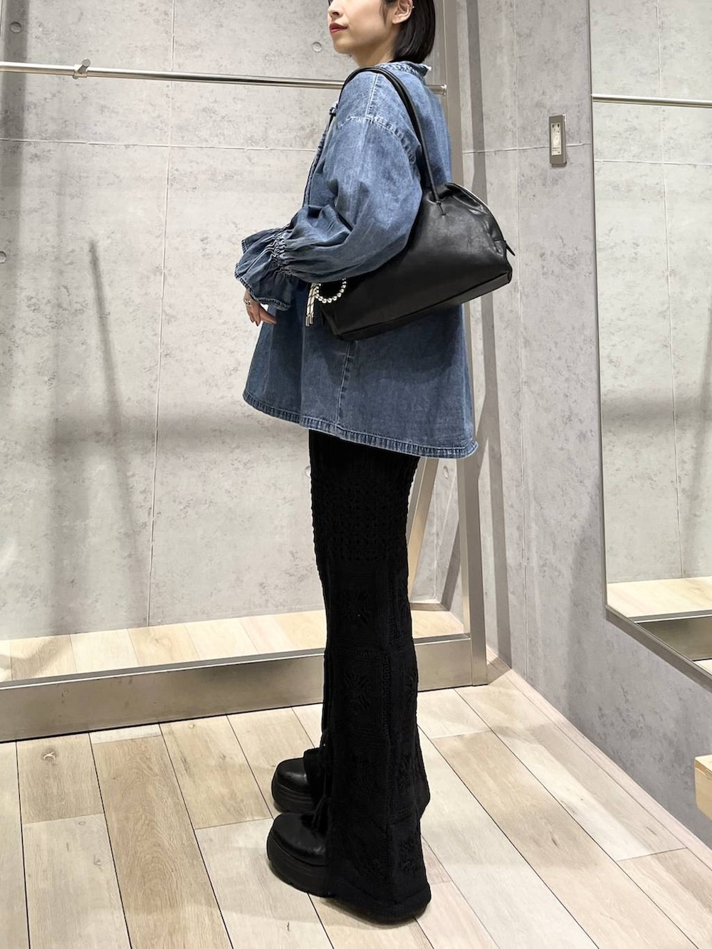 ブラック系のブーツ、ブラック系のボストンバッグ、ブラック系のその他パンツを着用したレディースの冬コーディネートの4枚目の写真