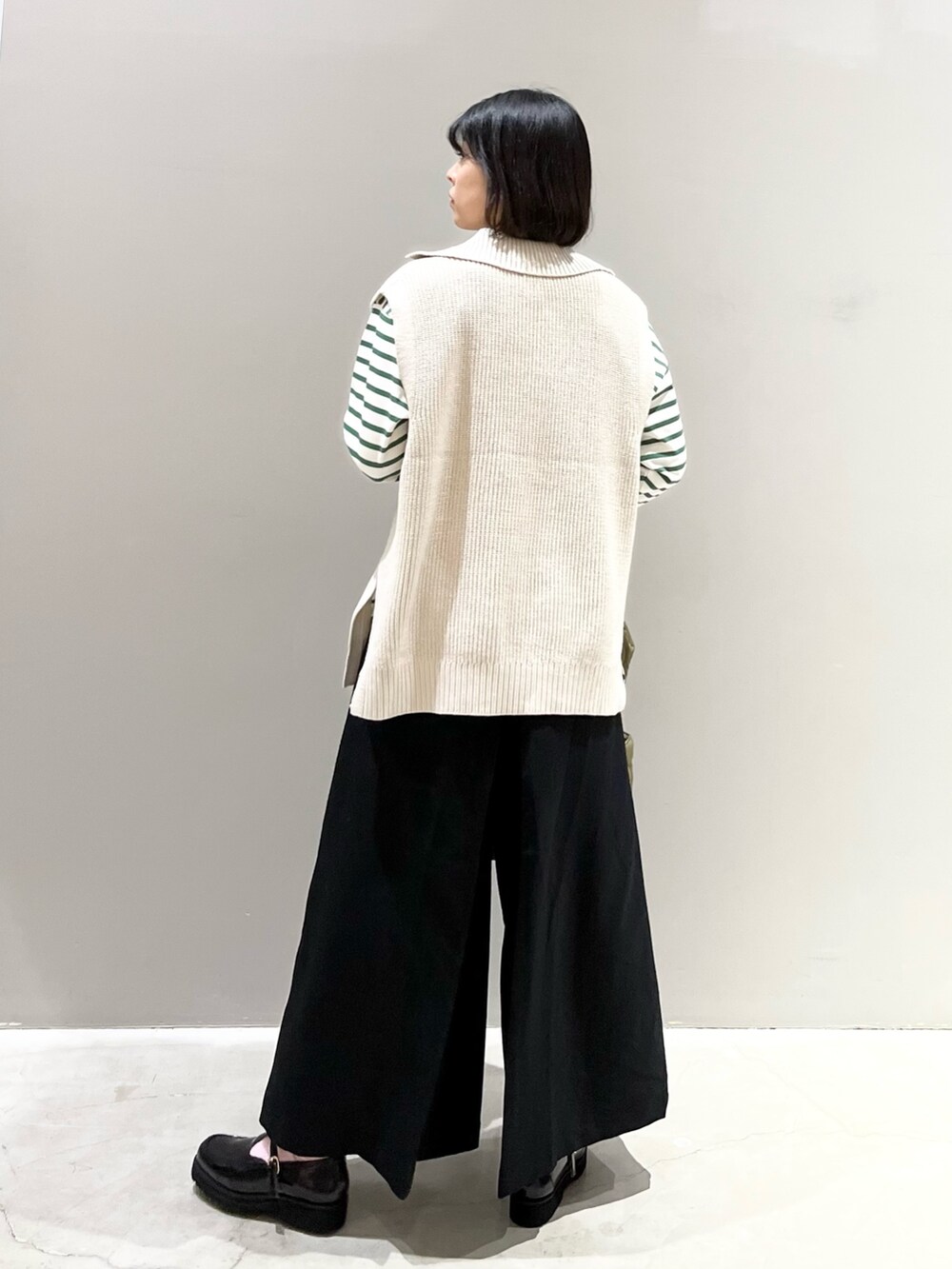 ブラック系のその他パンツ、ブラック系のローファー、グリーン系のバッグを着用したレディースの春コーディネートの5枚目の写真