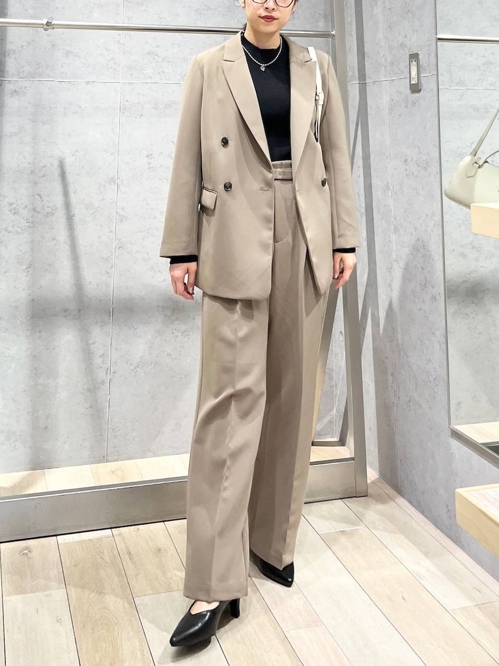 ブラック系のニット/セーター、ブラウン系のスーツパンツ、ブラック系のパンプスを着用したレディースの冬コーディネートの7枚目の写真