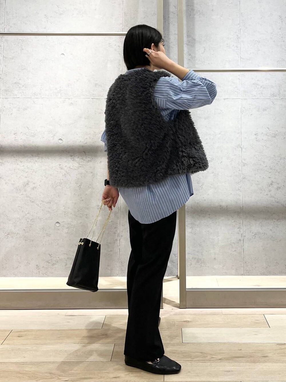 グレー系のベスト、ブラック系のその他パンツ、ブラック系のローファーを着用したレディースの秋コーディネートの8枚目の写真