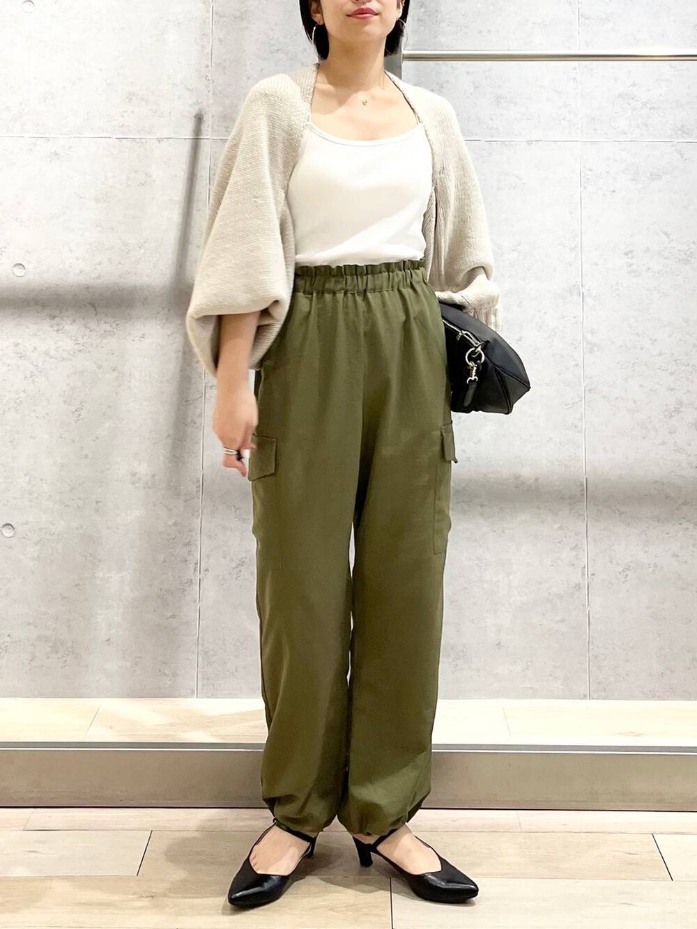 ホワイト系のキャミソール、ベージュ系のカーディガン/ボレロ、グリーン系のカーゴパンツを着用したレディースの秋コーディネートの5枚目の写真