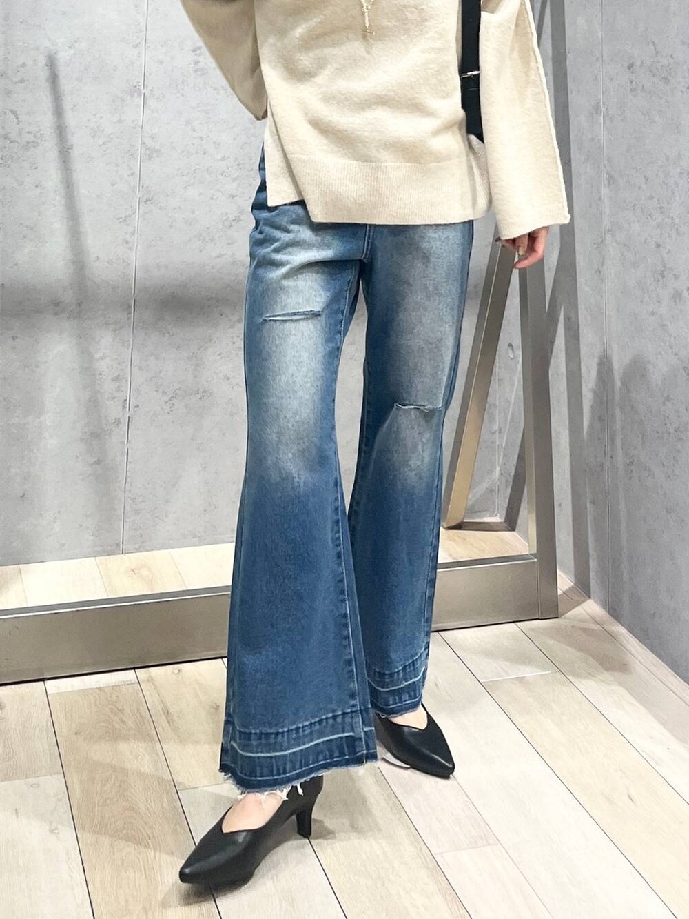 ブラック系のパンプス、ブラック系のショルダーバッグ、ベージュ系のニット/セーターを着用したレディースの冬コーディネートの6枚目の写真