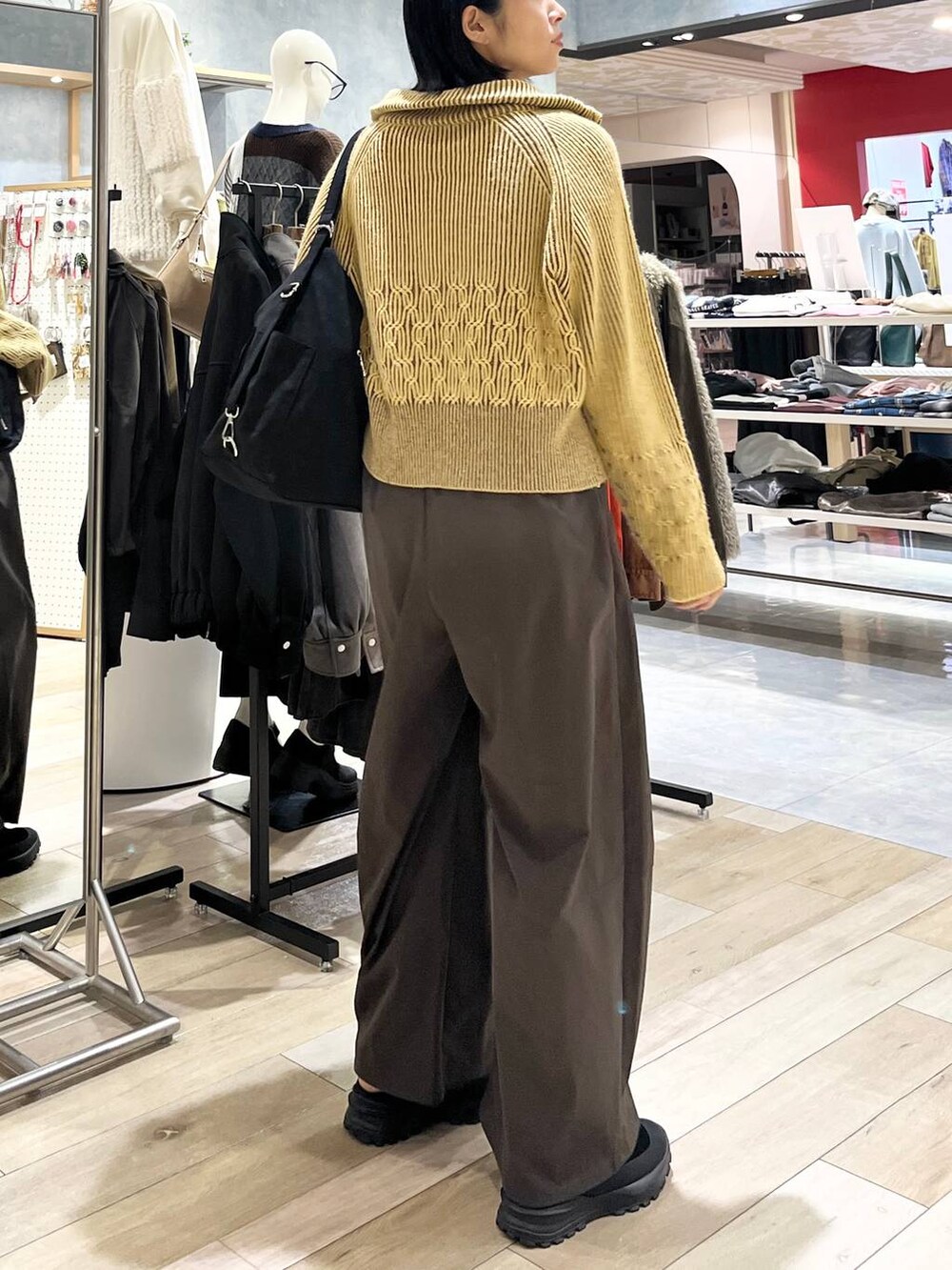 ブラウン系のその他パンツ、ブラック系のその他シューズ、ブラック系のショルダーバッグを着用したレディースの冬コーディネートの7枚目の写真