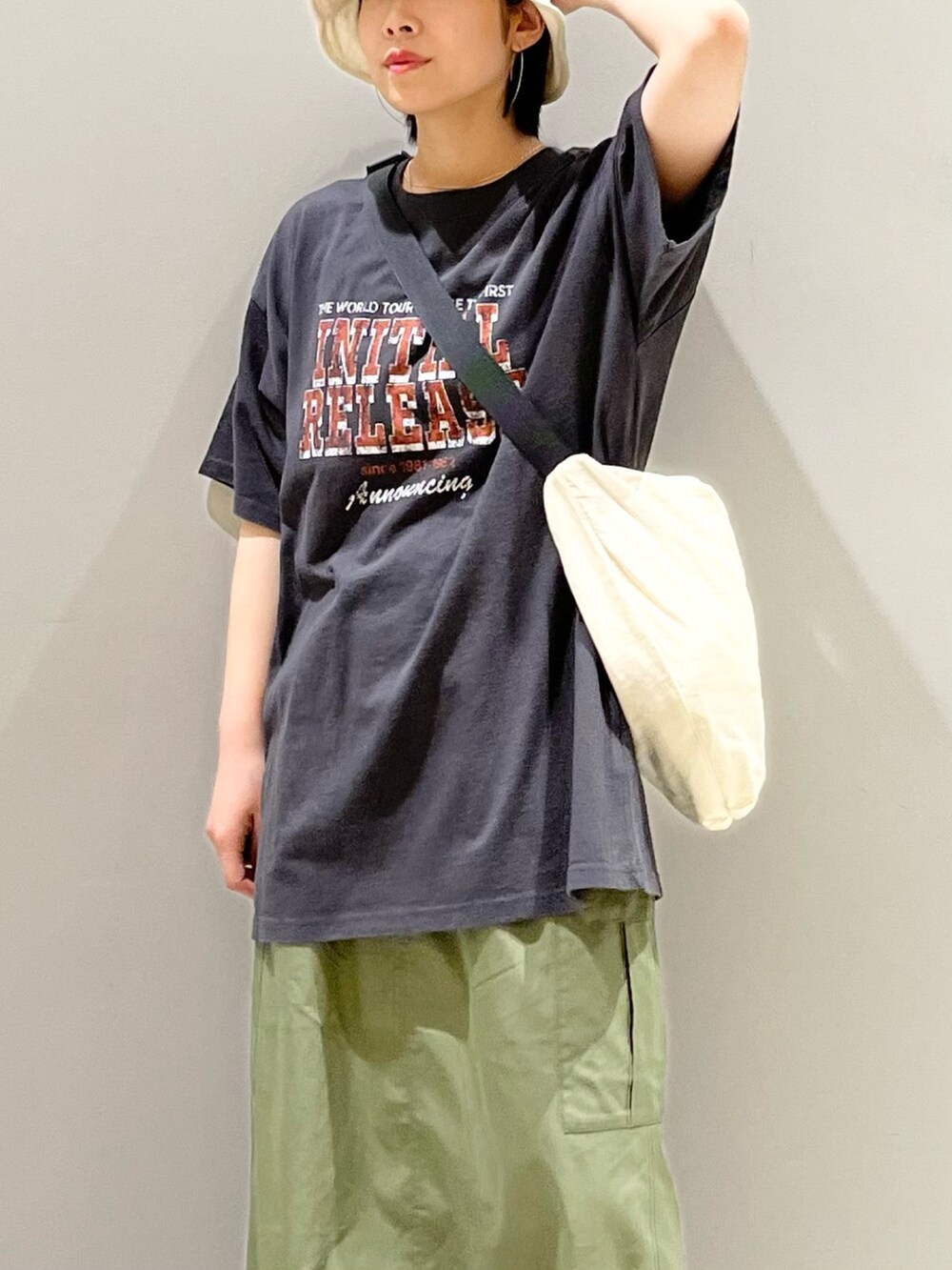 グレー系のTシャツ/カットソー、ホワイト系のショルダーバッグ、グリーン系のスカートを着用したレディースの夏コーディネートの3枚目の写真