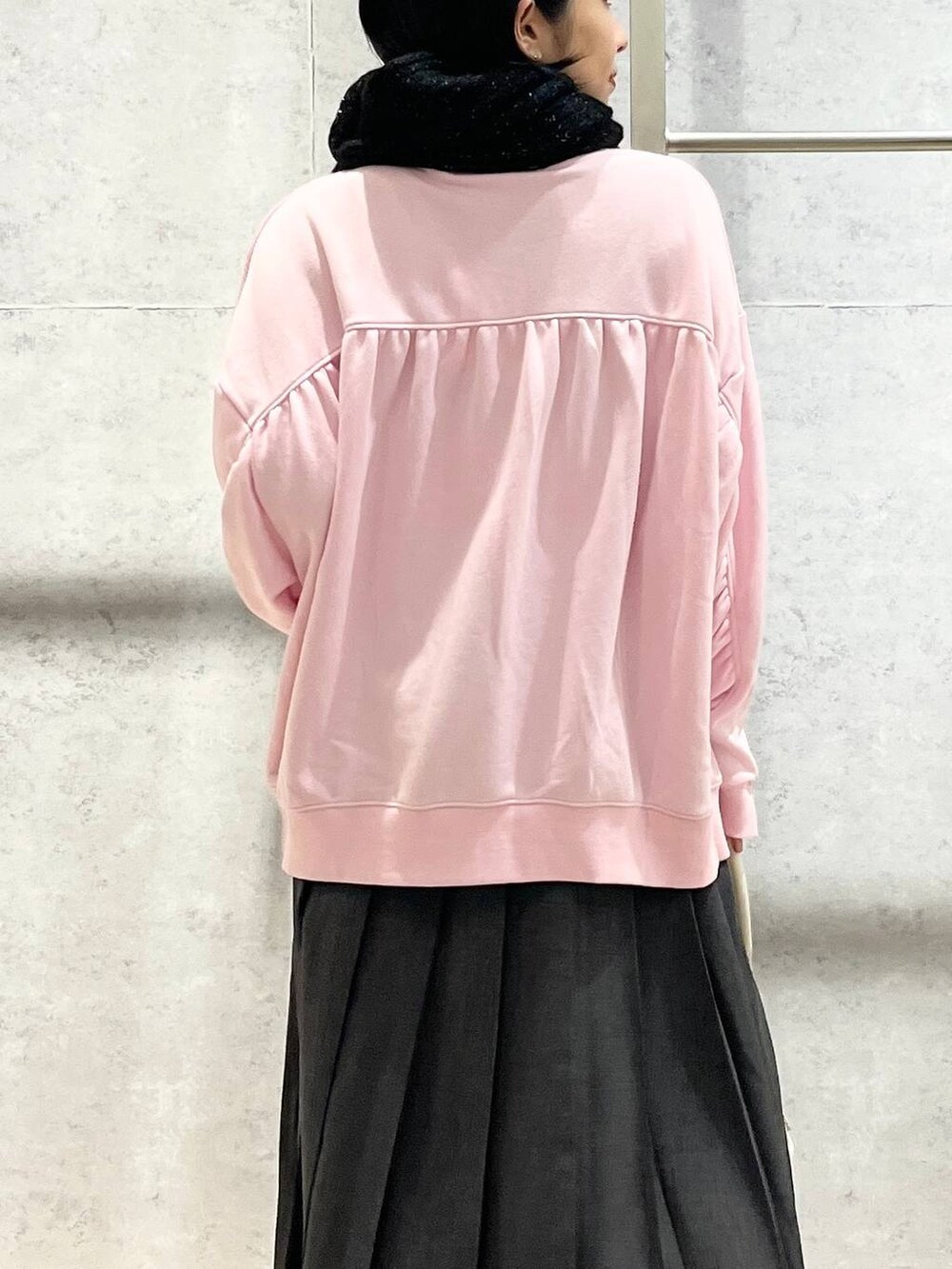 ホワイト系のショルダーバッグ、ピンク系のスウェット、ブラック系のブーツを着用したレディースの秋コーディネートの8枚目の写真