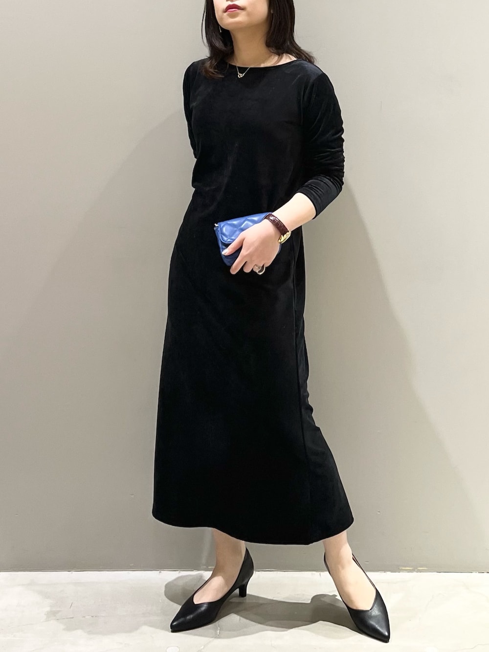 ブラック系のワンピース、ブルー系のショルダーバッグ、ブラック系のパンプスを着用したレディースの冬コーディネートの4枚目の写真
